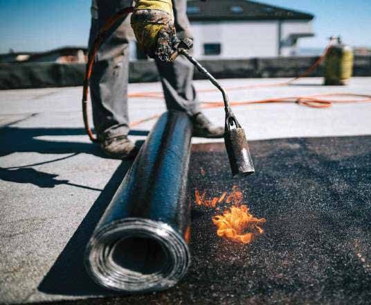 Worker handling pipe with a torch