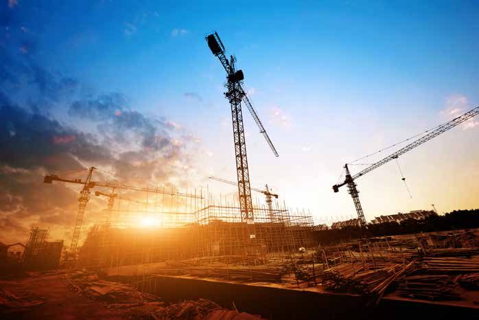 Cranes at a construction site at sunset